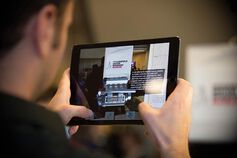 Male holds an ipad viewing the Indianapolis Motor Speedway Museum.